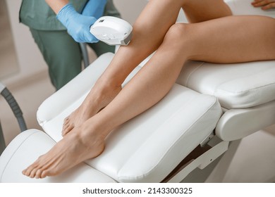 Smooth skin of legs. Photo epilation procedure in beauty salon. Woman in underwear sitting on daybed
