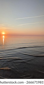 smooth surface of water at sunset. reflection of sun in water.