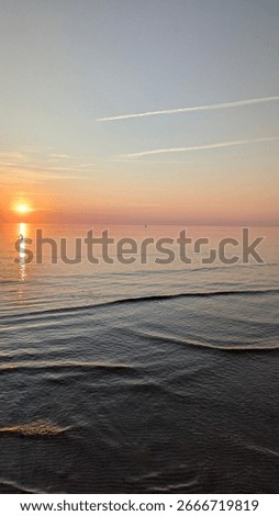 smooth surface of water at sunset. reflection of sun in water.