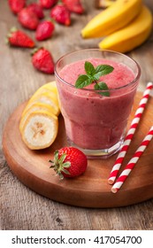 Smoothie With Banana And Strawberry In The Glass, Fresh Strawberries And Bananas On The Old Wooden Background