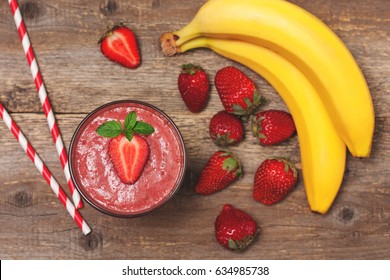 Smoothie With Banana And Strawberry In The Glass, Fresh Strawberries And Bananas On The Old Wooden Background