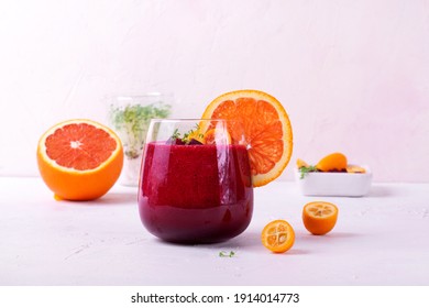 Smoothie With Beet Root, Berries And Blood Orange Topped With Microgreen In A Glass On White