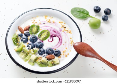 Smoothie Bowl With Acai Berry, Kiwi, Blueberries, Almonds, Coconut, Bee Pollen And Baby Spinach On White Background. Healthy Smoothy Bowl. Concept Of Healthy Eating And Dieting