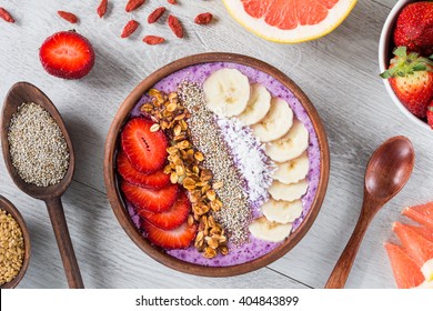 Smoothie bowl with chia seeds, muesli, strawberries, banana slices and coconut flakes - Powered by Shutterstock