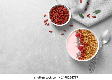 Smoothie bowl with goji berries and spoon on grey table, flat lay. Space for text - Powered by Shutterstock