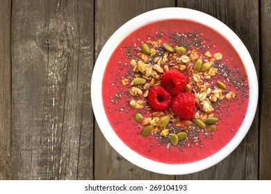 Smoothie Bowl With Raspberries, Granola And Chia Seeds On A Rustic Wood Background, Overhead View        