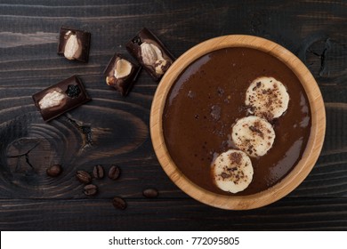Smoothie with chocolate at dark wooden background, top view