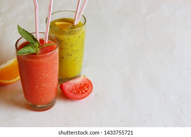 Smoothie Or Fresh Kiwi Orange And Tomato Basil In Glasses. Light Background, Horizontal Orientation, Copy Space