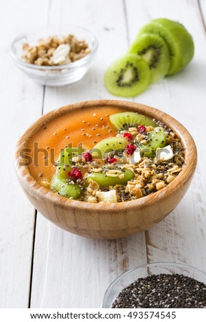 Smoothie with fruit,cereals and chia on white wooden table