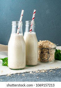 Smoothie With Oatmeal, Mint For Healthy Breakfast. Oat Milk In Glass Bottle With Tube On Dark Stone Background