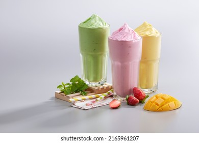 Smoothies Ice Blended Mixed Fruits Mango Strawberry Avocado With Fresh Fruits Decoration On White Background. Summer Tropical Smoothies Juice Drinks Smoothie Mixer Blending Fruit