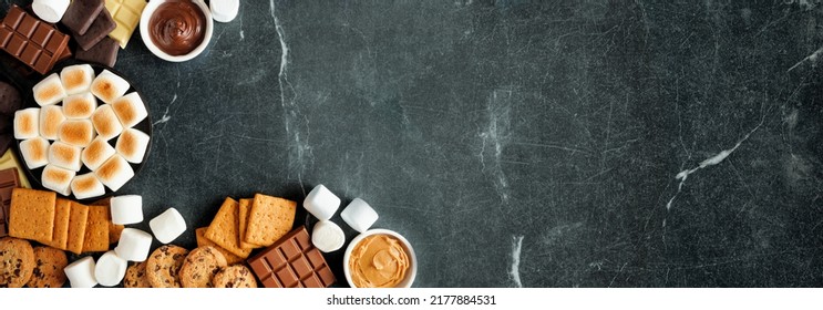 Smores Buffet Corner Border. Roasted Marshmallows, Crackers, Chocolate And A Variety Of Ingredients. Overhead View Over A Dark Stone Background.