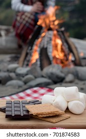 Smores Ingredients At A Beach Bonfire With Chocolate, Marshmellow, And Graham Crackers With Room For Copy