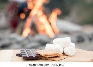 Smores Ingredients At A Beach Bonfire With Chocolate, Marshmellow, And Graham Crackers With Room For Copy