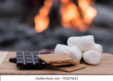 Smores Ingredients At A Beach Bonfire With Chocolate, Marshmellow, And Graham Crackers With Room For Copy