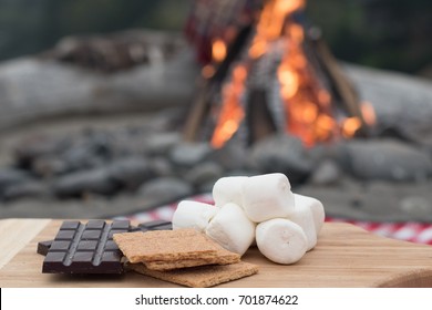 Smores Ingredients At A Beach Bonfire With Chocolate, Marshmellow, And Graham Crackers With Room For Copy