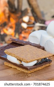 Smores Ingredients At A Beach Bonfire With Chocolate, Marshmellow, And Graham Crackers With Room For Copy