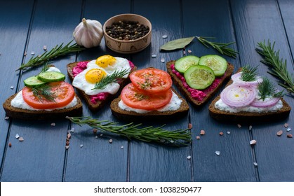 Smorgasbord. Open Sandwiches With Different  Toppings On The Dark Wooden Table. Healthy Food. Diet. 