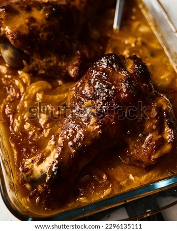 Smothered or stewed Turkey wings in a rectangular baking dish. Roasted to a crisp, the wings lie drowned in a thick gravy with vegetables. Food photo.