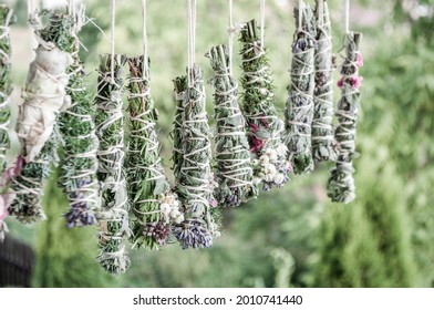 Smudge sticks on the rope. Dried herbs bound in bundles and hung on the rope. - Shutterstock ID 2010741440
