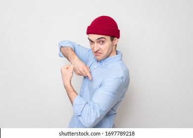 Smug Guy In A Red Cap And Blue Shows His Muscles At The Camera, Portrait