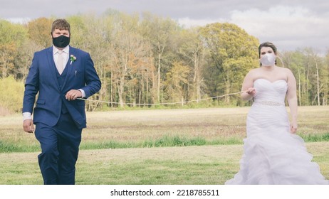 SMYRNA, UNITED STATES - May 07, 2020: A Bride And Groom In Protective Face Masks Standing Six Feet Apart