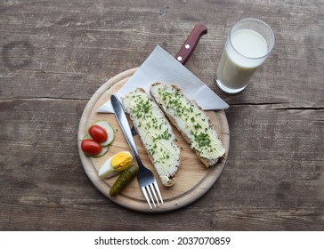 Snack at an alpine hut, typical dish with bead, butter, egg, tomato, cucumber and raw milk, on rustic wood table; South Tyrol, Italy