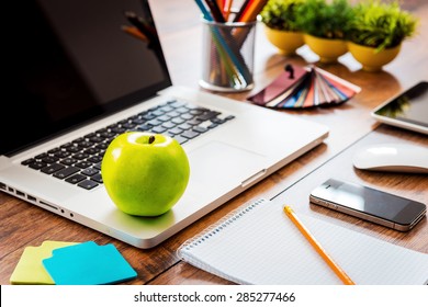 Snack for business productivity. Close-up ofcomfortable working place in office with wooden table and laptop laying on it - Powered by Shutterstock