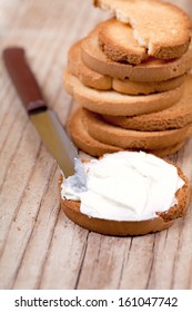 Snack Crackers With Cream Cheese And Knife On Wooden Background