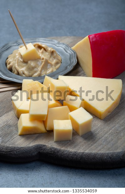 Snack food, blocks of Dutch red ball Edam cheese\
and mustard