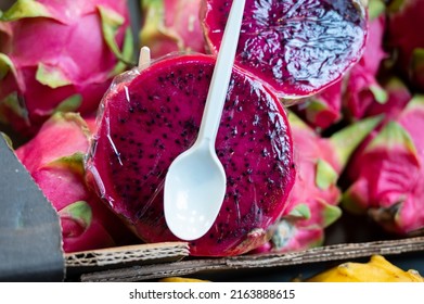 Snack fruits, half of ripe colorful dragonfruit on Spanish market, ready to eat, close up