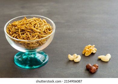 Snack insects. Mealworm larvae as food and variation of nuts. Mealworms crustaceans tenebrio molitor, freeze-dried for snacking. Fried worms. Roasted mealworms. Animal snack concept