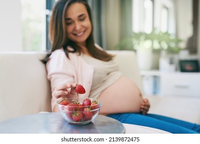 Snacking Healthy. Shot Of A Pregnant Woman Snacking On Strawberries.