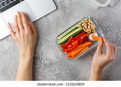 Snacking at work. Woman eating healthy snacks at work. Vegetable diet snacks. Glass container - Shutterstock ID 2132618829