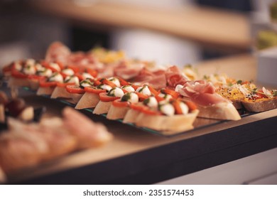 Snacks for the holiday, catering. Various light snacks. Catering plate. Assortment of sandwiches on the buffet table. meat, fish, nuts, cheese, vegetable canapes ofcelebration of important event. 
