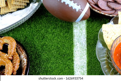 Snacks For Watching A Football Game. Great For Super Bowl Or Playoff Themed Projects. Pretzels, Sausage, Chips And Dips With A Football And A Faux Grass Background