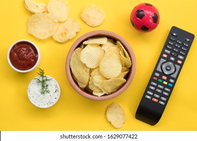 Snacks for watching TV on yellow background top view mock-up.The concept of TV viewing and sports tournaments.