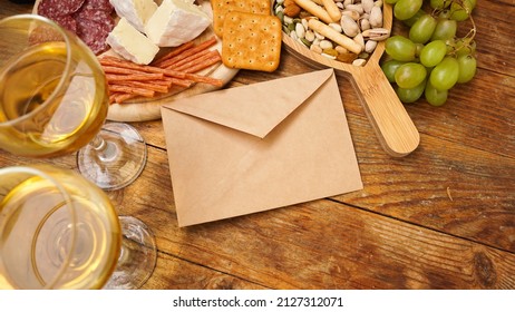 Snacks For Wine. Cheese And Meat Plate With An Envelope. An Invitation To A Romantic Dinner For Lovers. Sausages, Cheese, Nuts, Grapes, Crackers, Wine