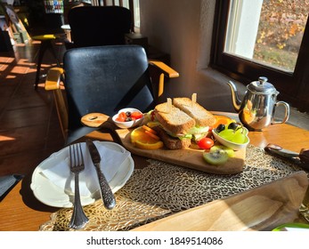 snadwich and fruit with fork and knife