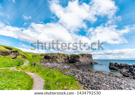 Snaefellsjokull, Iceland - June 18, 2018: Landscape trail hiking view of rocky beach in Hellnar National park Snaefellsnes Peninsula with ocean and people in summer on trail