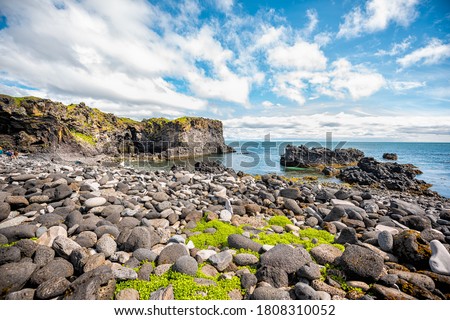 Snaefellsjokull, Iceland landscape trail view of rocky beach in Hellnar National park Snaefellsnes Peninsula with ocean and people