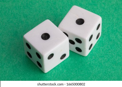 snake eyes - a pair of dice on a green background showing one and one - Shutterstock ID 1665000802