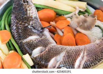 Snake Head Fish And Vegetable Are Steamed In Stainless Steamer Pot  On The Stove