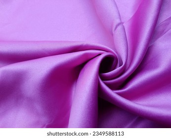 A snapshot of opulence, the purple satin fabric captures attention with its royal hue. The satin's smooth texture shines, adding a touch of extravagance to the scene.