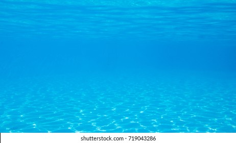 Snapshot under the water of a beautiful blue pool on a sunny day