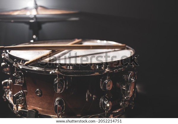 Snare drum, percussion instrument on a dark\
background with stage\
lighting.