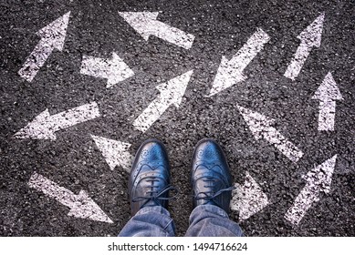 Sneaker shoes and arrows pointing in different directions on asphalt ground, choice concept - Powered by Shutterstock