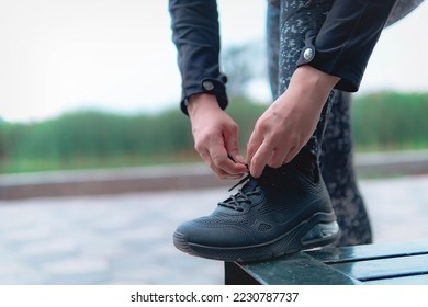 Sneakers. close up of a woman tying shoelaces. Women's sneaker ready for outdoor running in the park or forest. - Shutterstock ID 2230787737