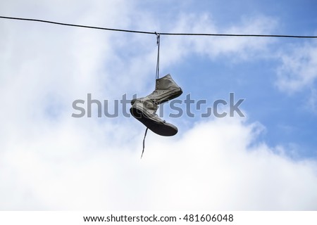 Sneakers hanging on wires on a background of blue sky. Sports Equipment.
