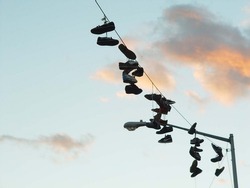 Sneakers Hung Around Telephone Wire In Brooklyn At Sunset